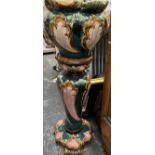 A Majolica jardiniere on a stand with raised decoration of flowers and leaves