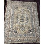 A rug with a gold ground decorated with a central medallion,