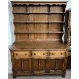 An Ercol dresser with a rectangular cornice above three shelves,