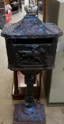 A cast iron post box with a caddy top and crown surmount on a pedestal and rectangular base,