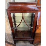 A 20th century mahogany display cabinet with a caddy top above a glazed door and glazed sides and a