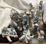 A collection of Lladro and Nao figures including a boy cuddling puppies, a panda, geese,