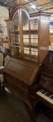 An early 20th century oak bureau bookcase with a domed top and a pair of glazed doors,