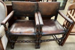 A pair of oak elbow chairs with a leather back and seat on turned legs