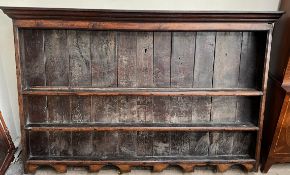 An 18th century oak dresser rack, with a moulded cornice above three shelves with a shaped base,