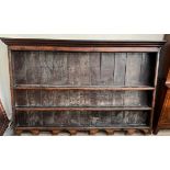 An 18th century oak dresser rack, with a moulded cornice above three shelves with a shaped base,