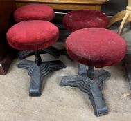 A set of four stools with circular pad seats on a trefoil cast iron base