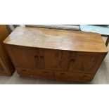 An Ercol light elm sideboard with three cupboards above two drawers on casters, 129.5cm wide x 75.