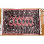 A Turkoman rug with a pink ground, with a floral border and guard stripes,