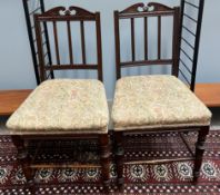 A pair of Edwardian salon chairs with stick back and pad seat on turned legs