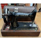 A Singer sewing machine contained in a domed oak box