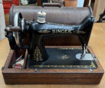 A Singer sewing machine contained in a domed oak box