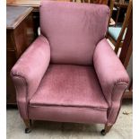 An Edwardian upholstered mahogany library chair on square tapering legs and casters