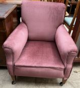 An Edwardian upholstered mahogany library chair on square tapering legs and casters