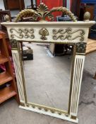 A cream and gilt decorated wall mirror of rectangular form with an arched leaf cresting with