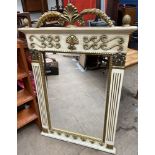 A cream and gilt decorated wall mirror of rectangular form with an arched leaf cresting with