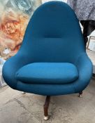 A mid 20th century upholstered egg type swivel chair on a teak base and brass feet