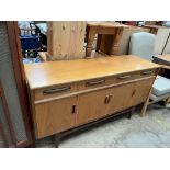 A mid 20th century G-Plan teak sideboard of rectangular form with four drawers and four cupboards