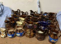 A collection of copper lustre jugs together with an opaque glass rolling pin