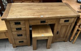 A modern oak desk with six drawers and a cupboard together with a similar side table