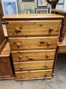 A pine chest with five drawers on flattened bun feet