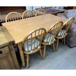 A modern dining table and six stick back dining chairs