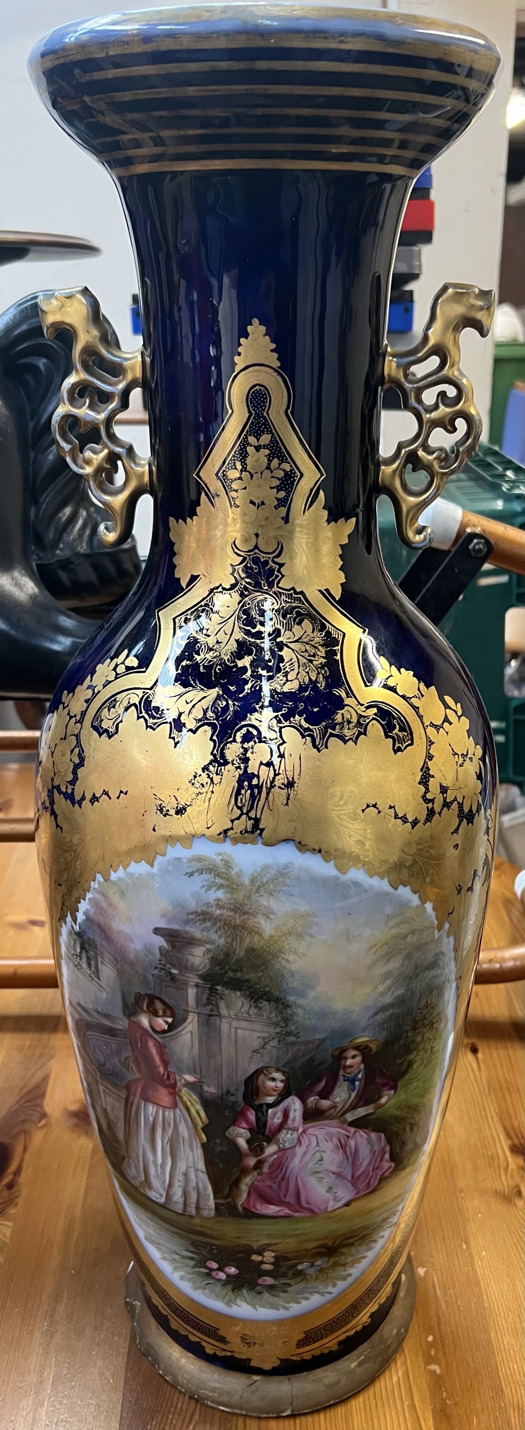 A large continental porcelain twin handled vase decorated with figures in a landscape, 70.