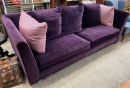 A large purple upholstered Colin and Hayes three seater settee on bracket feet