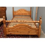 A pine double bed with an arched head and foot board