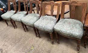 A set of five Victorian dining chairs with carved dished back above a pad seat on turned front legs