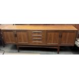 A G-Plan teak sideboard with four central drawers flanked by two pairs of cupboards on tapering