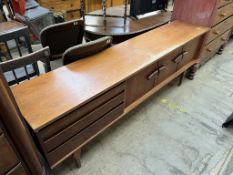 A mid 20th century teak sideboard with three drawers and three cupboards on tapering legs,