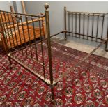 A brass double bed with spindle uprights