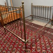 A brass double bed with spindle uprights