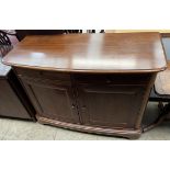 A modern mahogany sideboard with a bowed top above two drawers and two cupboards on bracket feet