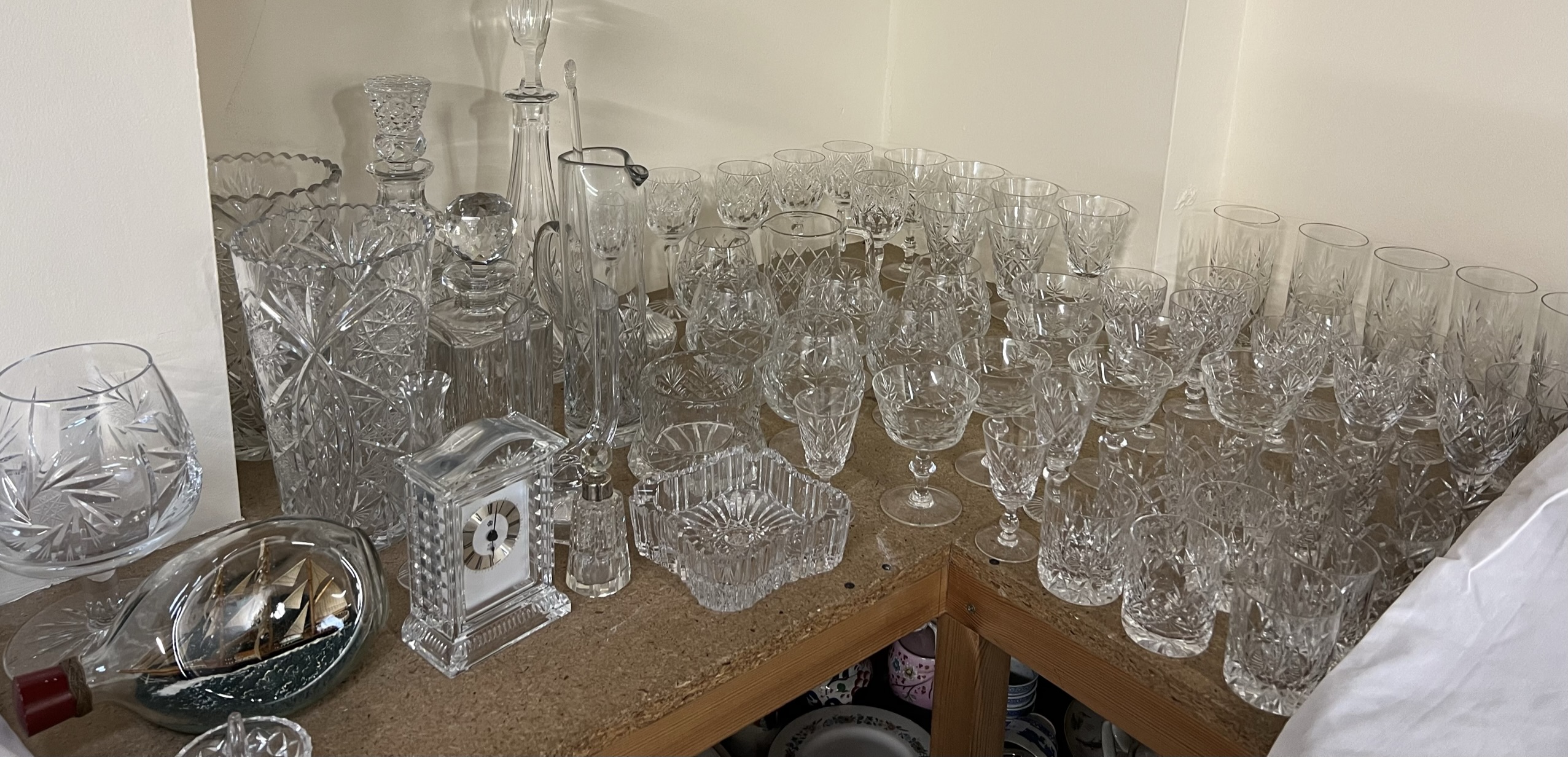 An extensive collection of crystal drinking glasses, crystal vases, decanters, desk clock,