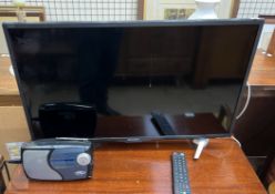 A Sharp 32" LCD television and remote together with a radio (Sold as seen,
