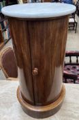 A Victorian mahogany pot cupboard with a circular marble top above a cylindrical body with a single