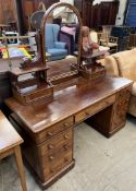 A Victorian mahogany dressing table with a domed mirror flanked by drawers above a central drawer