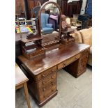 A Victorian mahogany dressing table with a domed mirror flanked by drawers above a central drawer