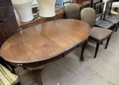 A 20th century mahogany extending dining table on cabriole legs and pad feet together with a pair