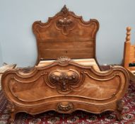 A French walnut double bed with a carved head and foot boards