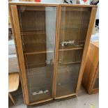 A pair of Ercol light elm display cabinets with a glazed door and shelves, each 46.