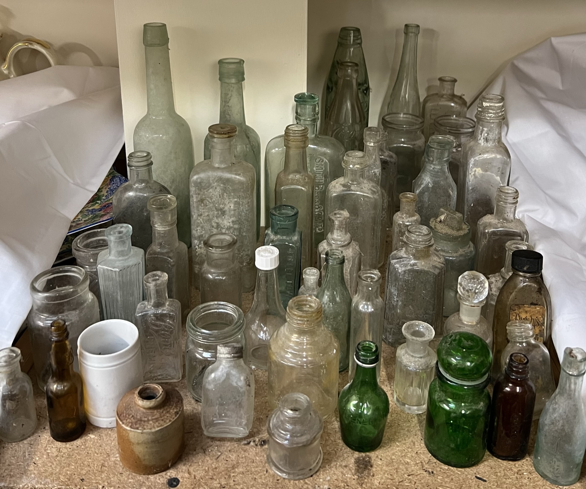 A collection of glass bottles including Coca Cola, Smith Bros,