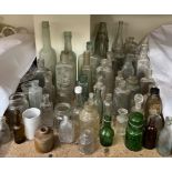 A collection of glass bottles including Coca Cola, Smith Bros,