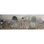 A collection of drinking glasses, crystal vases,
