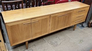 A mid 20th century teak sideboard with a rectangular top above three drawers,