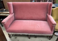 An Edwardian oak framed two seater settee on turned legs