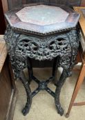 A Chinese hardwood jardiniere stand of octagonal form with a marble inset top above a flower and