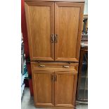 A mid 20th century teak G-Plan teak cocktail cabinet with a pair of cupboards enclosing a mirrored